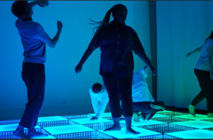 People dance on a blue dancefloor