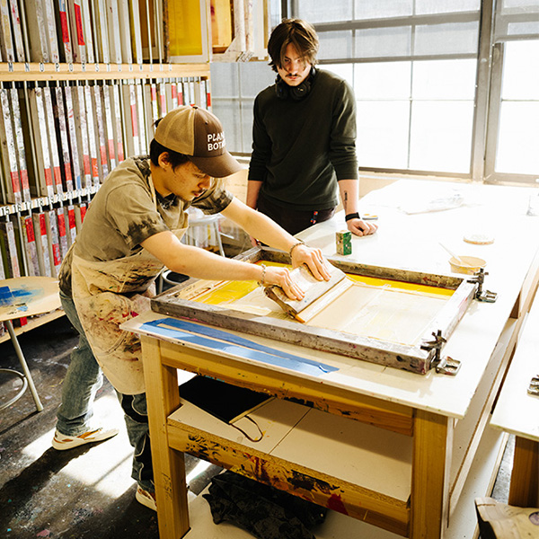 A student screen prints in MIAD's Printmaking Lab.