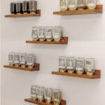 Floating shelves hold upside-down Mason jars filled with liquid and polaroid photos.