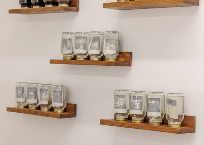 Floating shelves hold upside-down Mason jars filled with liquid and polaroid photos.