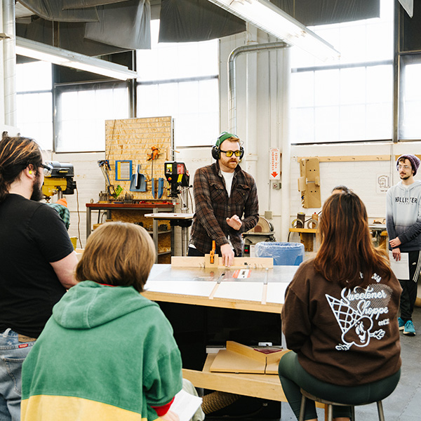 An instructor teaches a group of students in MIAD's 3D Lab