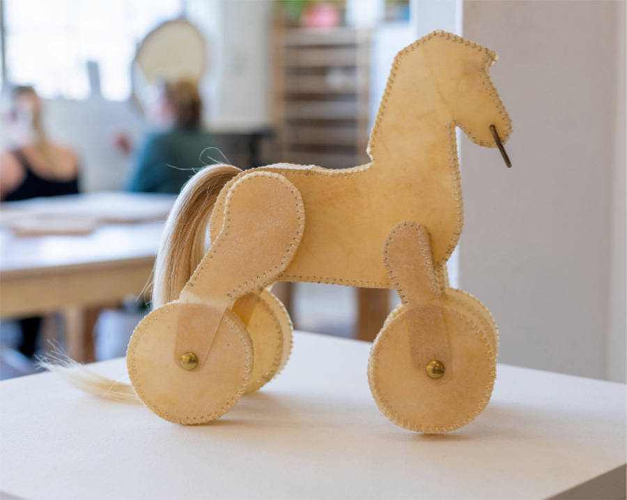 A fabric sculpture of a rolling horse with real hair for its tail.
