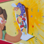 A page of a book with a person looking at a 3D papercut illustration of halo-halo.