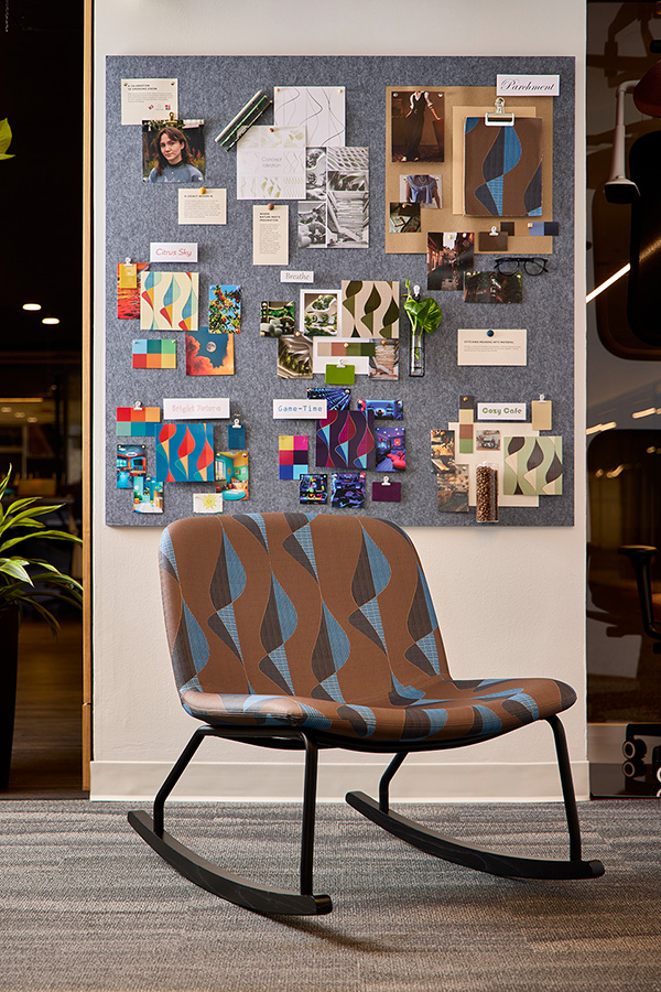A chair sits in front of a moodboard in a showroom.