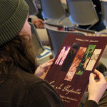 A person holds a program for "Love in Perspective," a hypothetical exhibition.