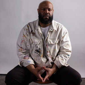 Color photograph of Kevin Brown, Jr. seated with hands touching