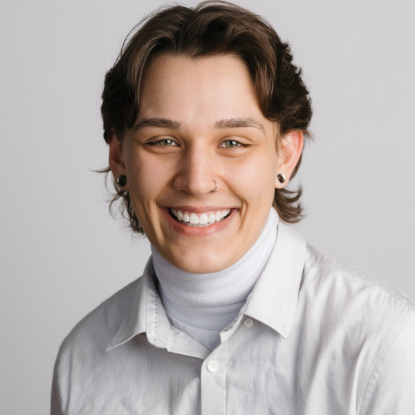 Color photograph of young woman with short hair smiling into camera