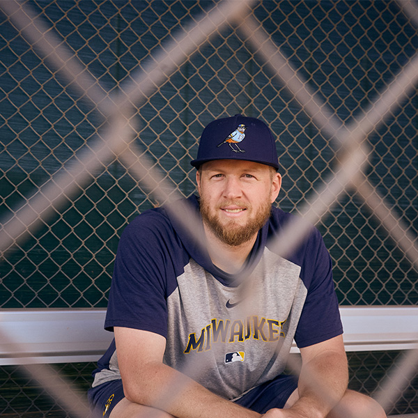 Brewers Pitcher Jared Koenig sits behind a fence