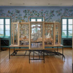 Wood, steel and glass installation of ceramics in a highly decorative room facing a body of water.