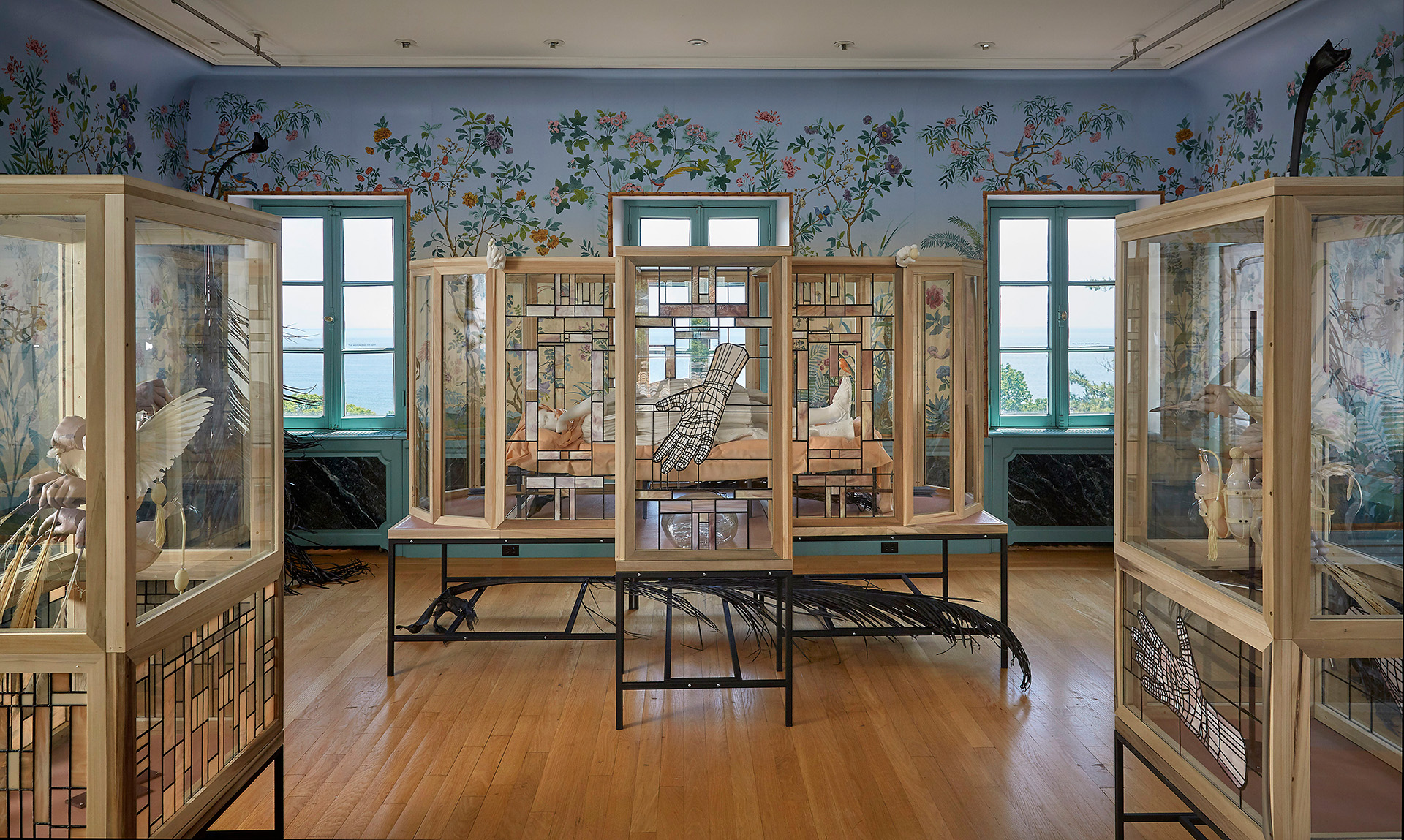 Wood, steel and glass installation of ceramics in a highly decorative room facing a body of water.
