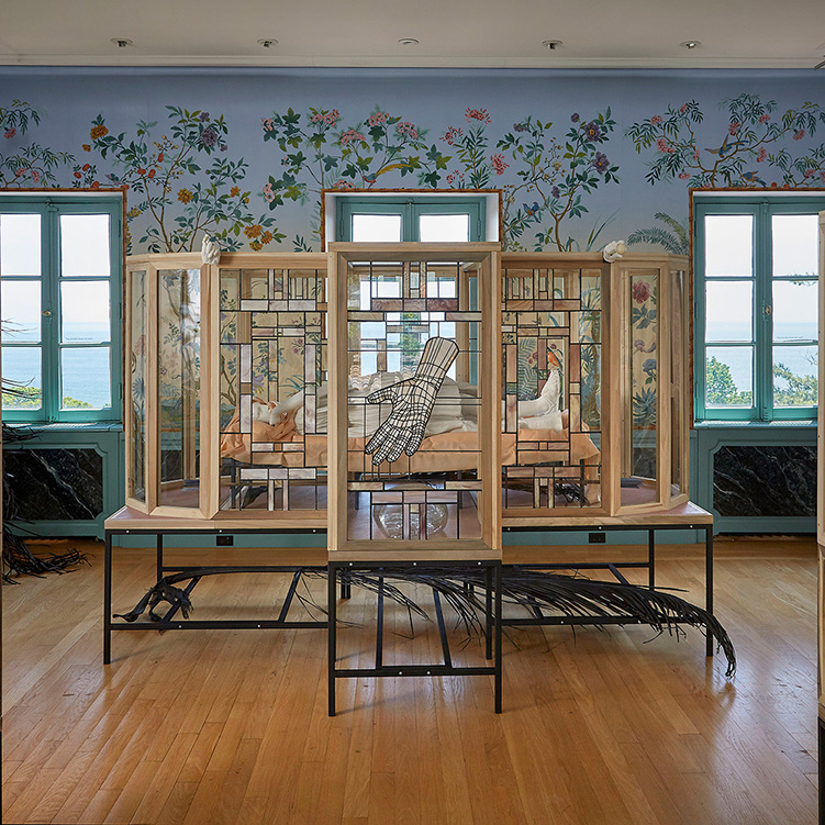 Wood, steel and glass installation of ceramics in a highly decorative room facing a body of water.