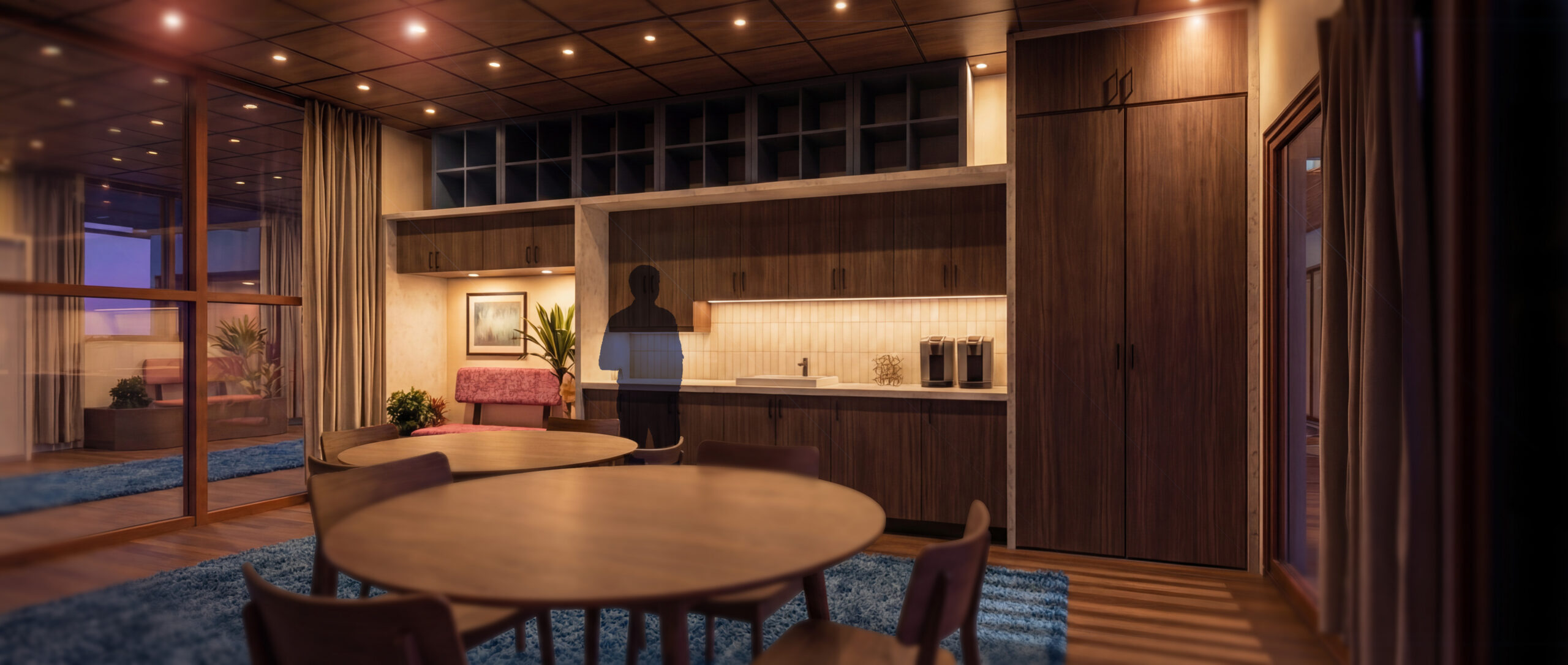 Wood-paneled open-plan dining area with round table and kitchen along the back wall.