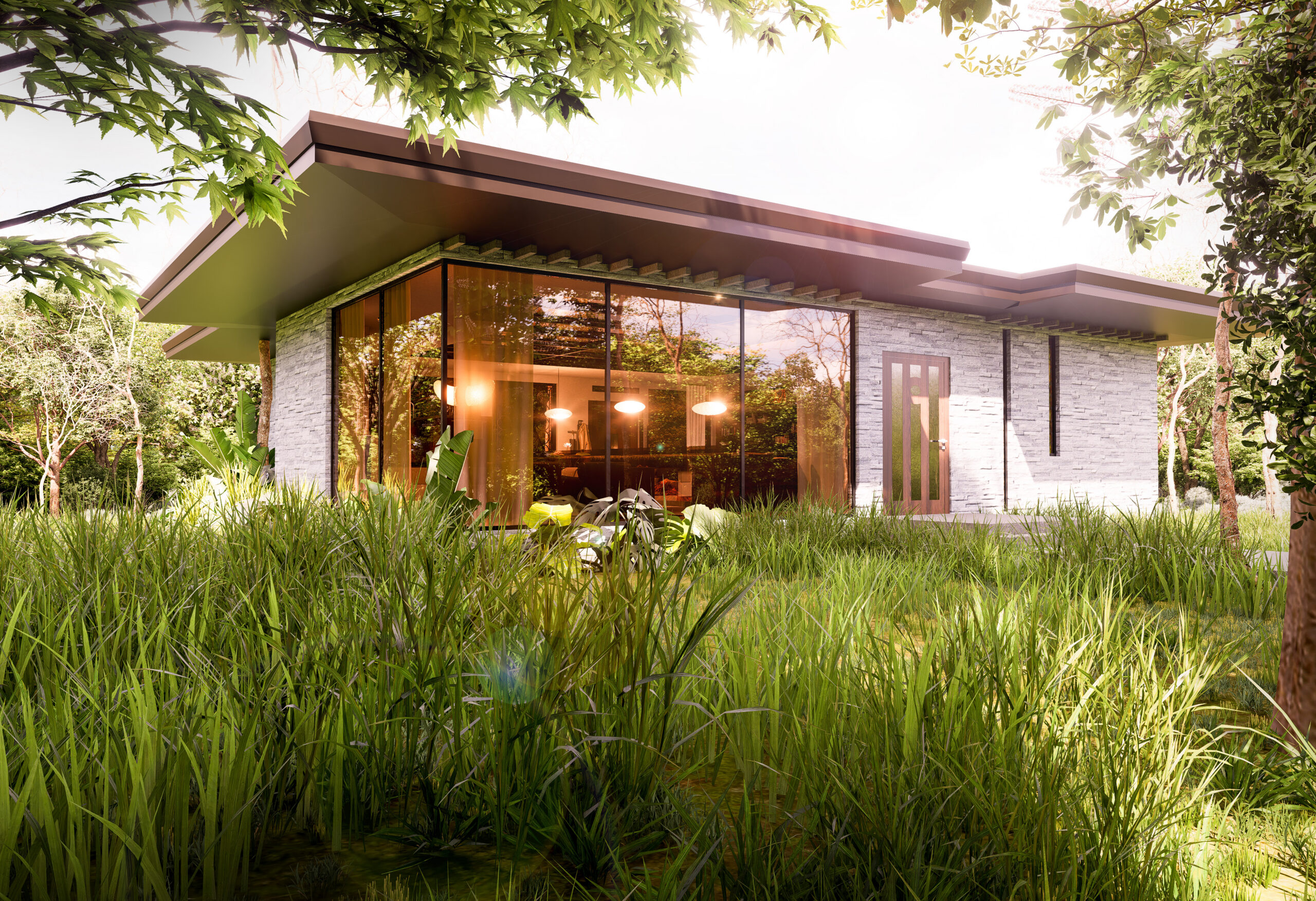 Single-story modern glass-and-stone house set in tall meadow grass and trees, with large floor-to-ceiling windows revealing a warmly lit interior and a low overhanging roof.