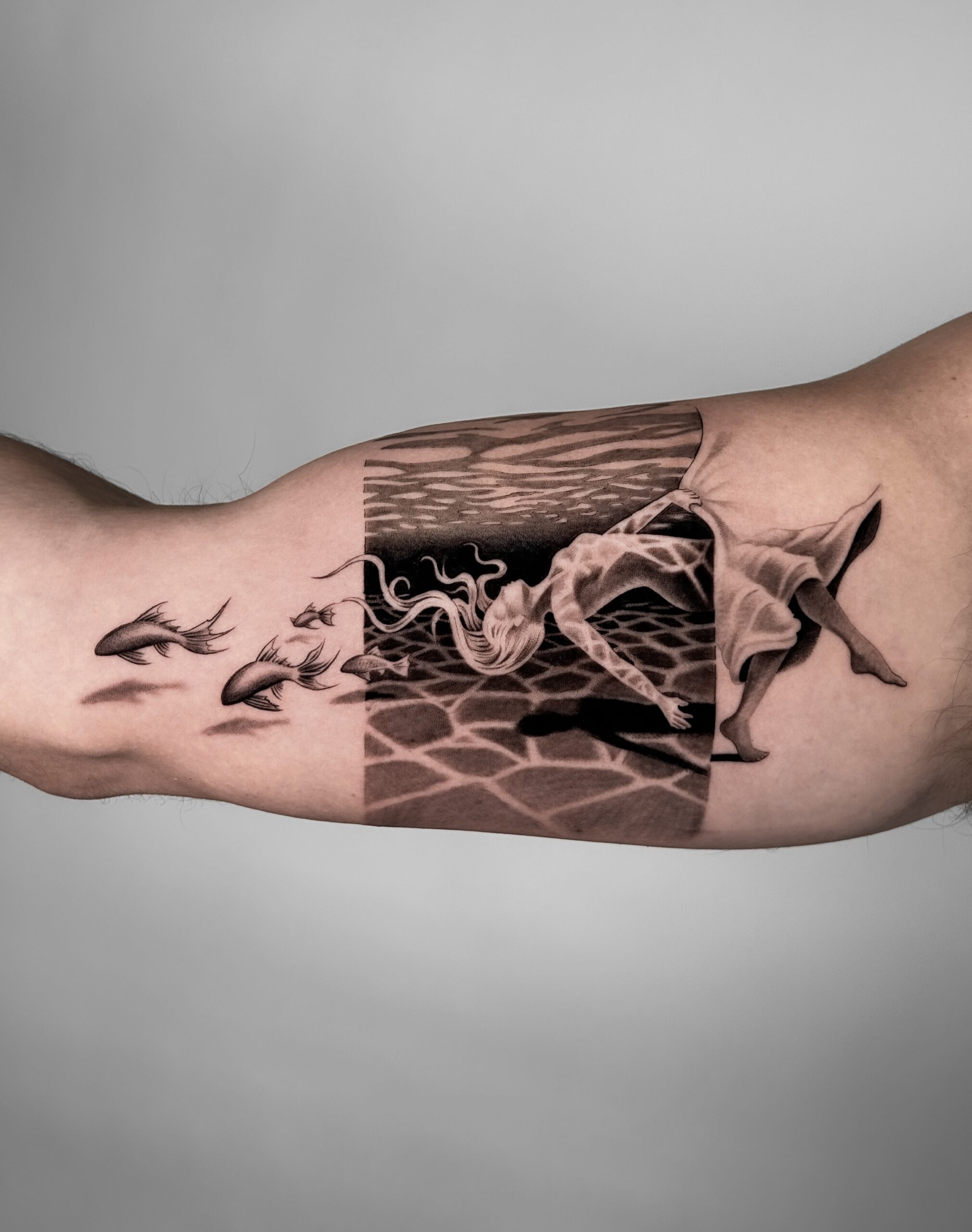 surrealist black tattoo on bicep