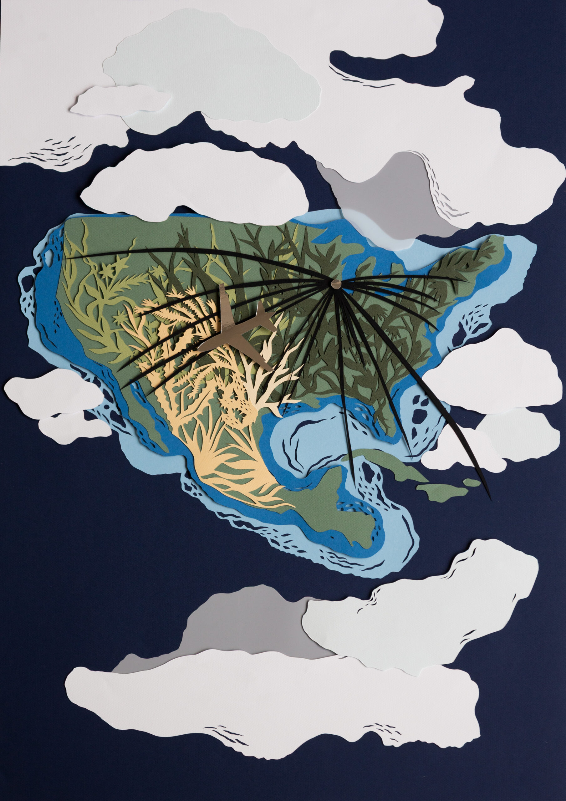 Kelly Wendorf Papercut 01 Layered paper-cut artwork depicting a landscape surrounded by clouds. A small airplane flies across a map-like landmass featuring rivers, vegetation, and coastline details, all rendered in shades of blue, green, cream, and white.